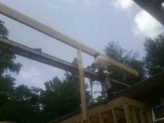 Carpenter setting a ridge beam over a new addition frame — Ice Dam Removal by Roofing Brothers in Crouse