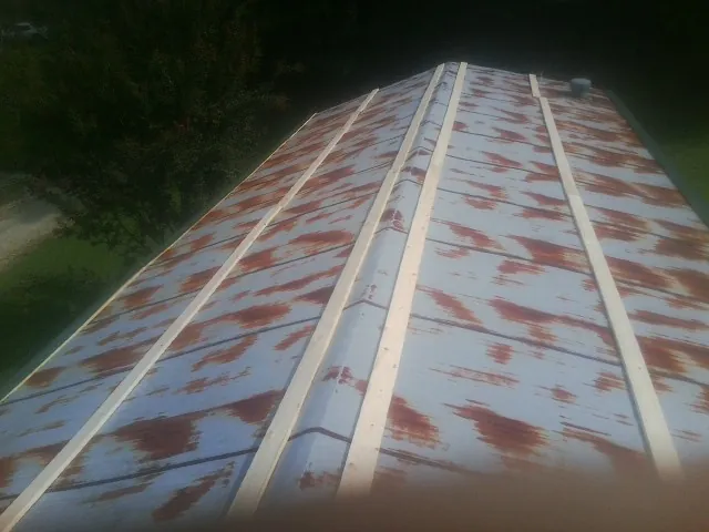 Rusted metal roof panels with new wood purlins before replacement — Storm Damage Roof Repair in Crouse by Roofing Brothers